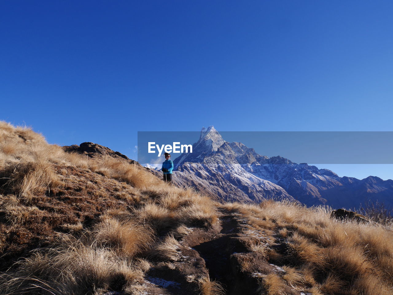 Rear view of man standing on mountain against sky