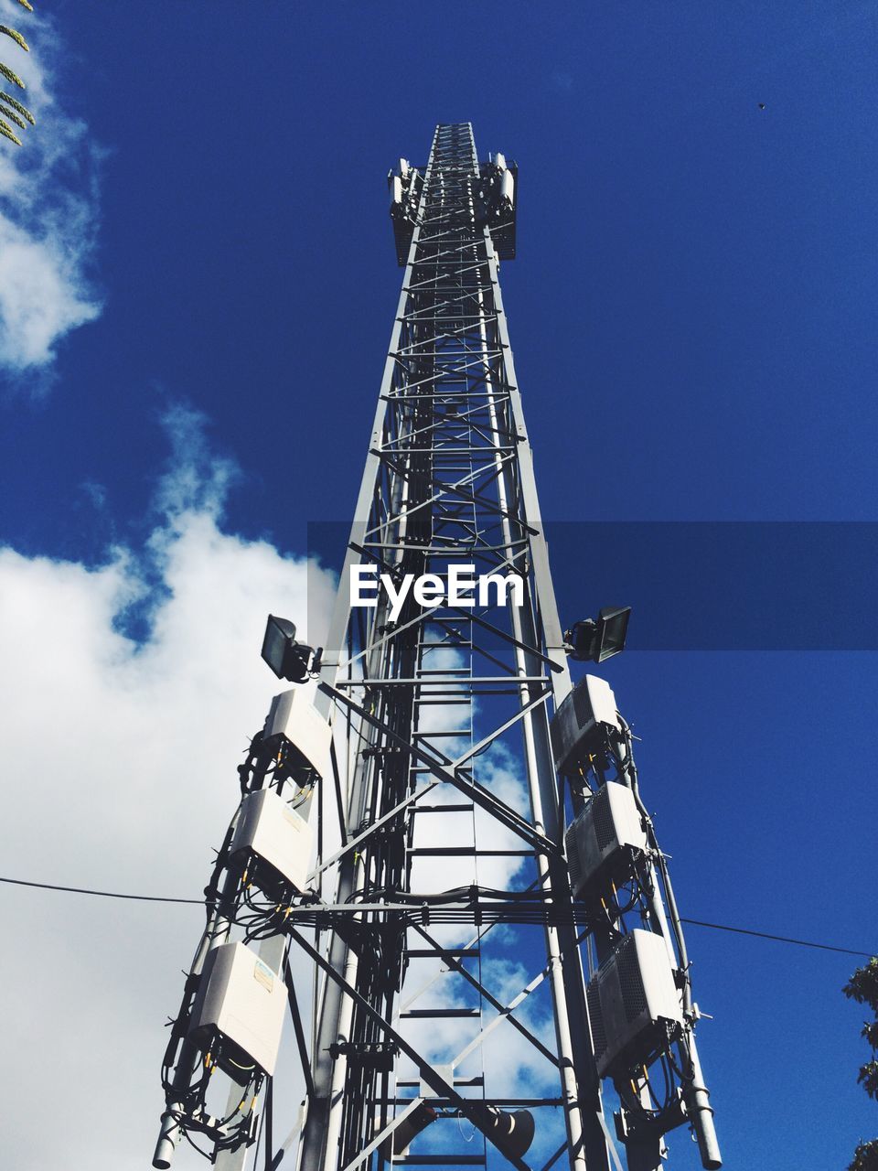 Low angle view of communication tower against blue sky
