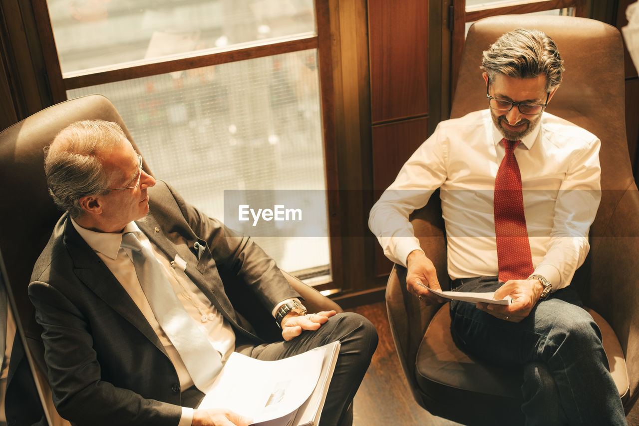 High angle view of legal colleagues discussing over documents at law office