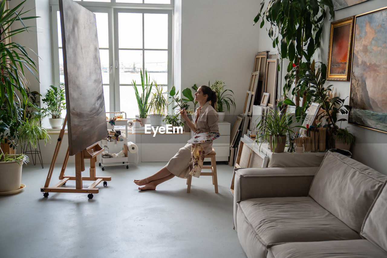 portrait of woman sitting on sofa at home