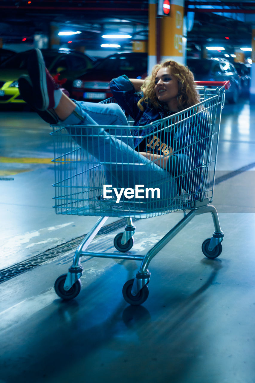Woman sitting in shopping cart