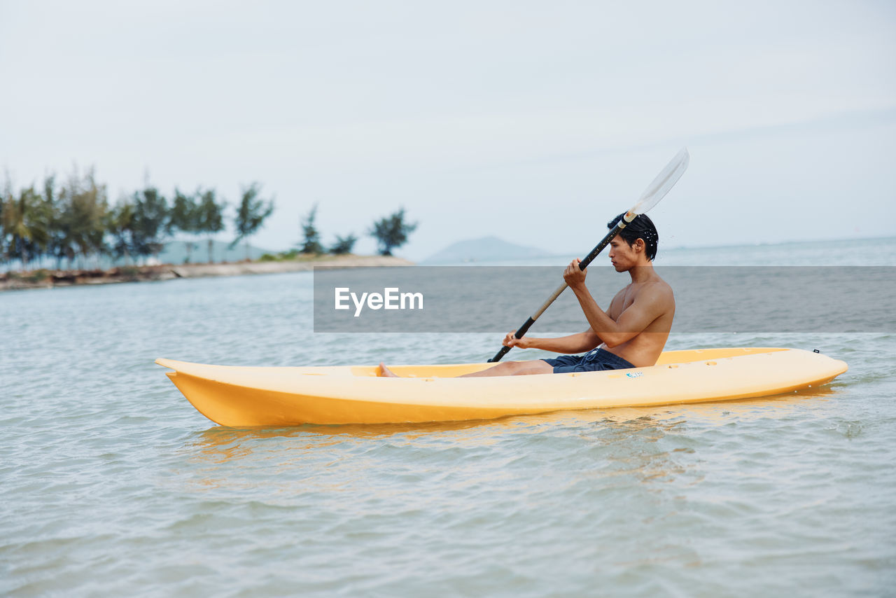 rear view of woman kayaking in sea