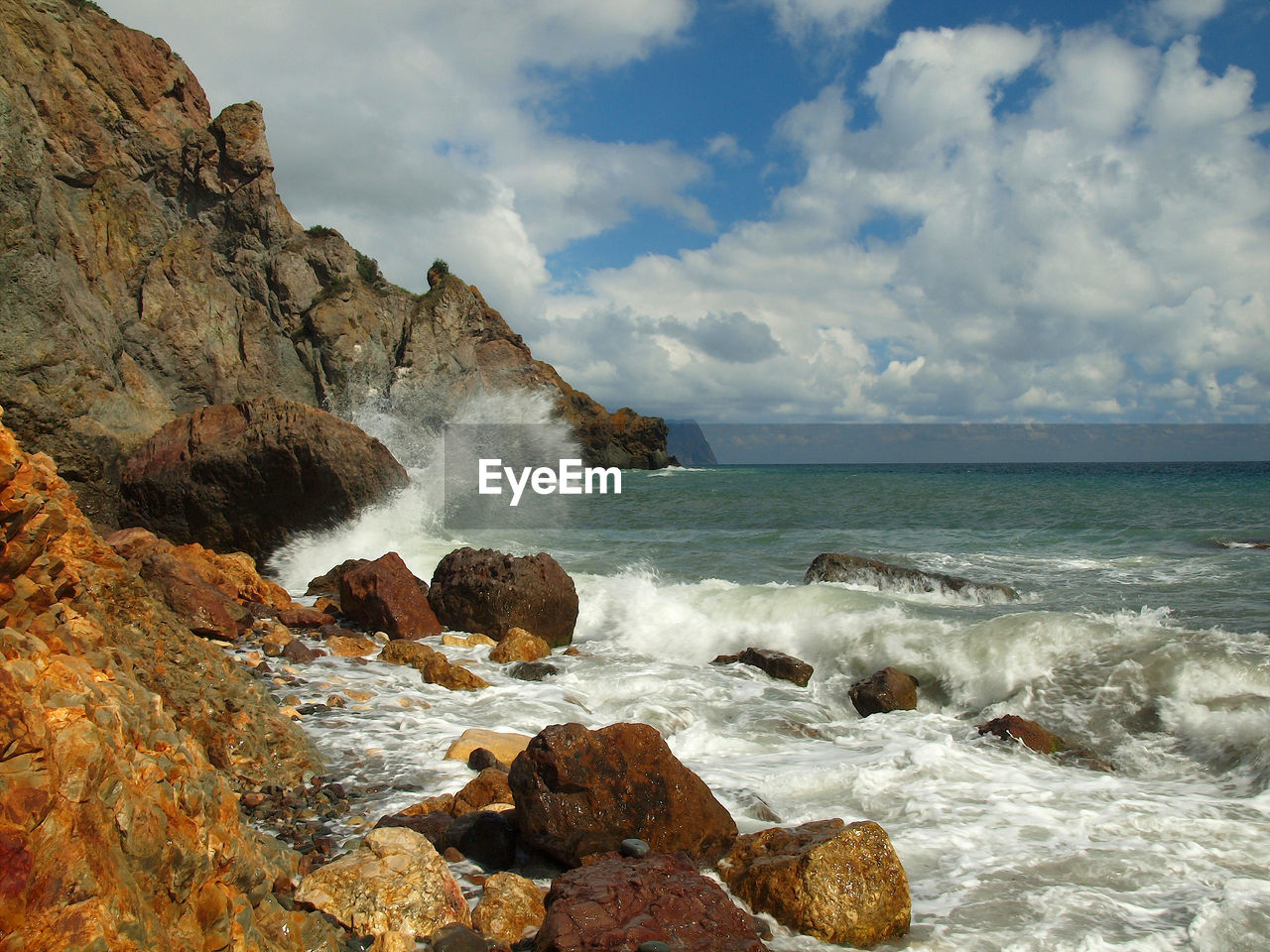 SCENIC VIEW OF SEA WAVES SPLASHING ON ROCKS