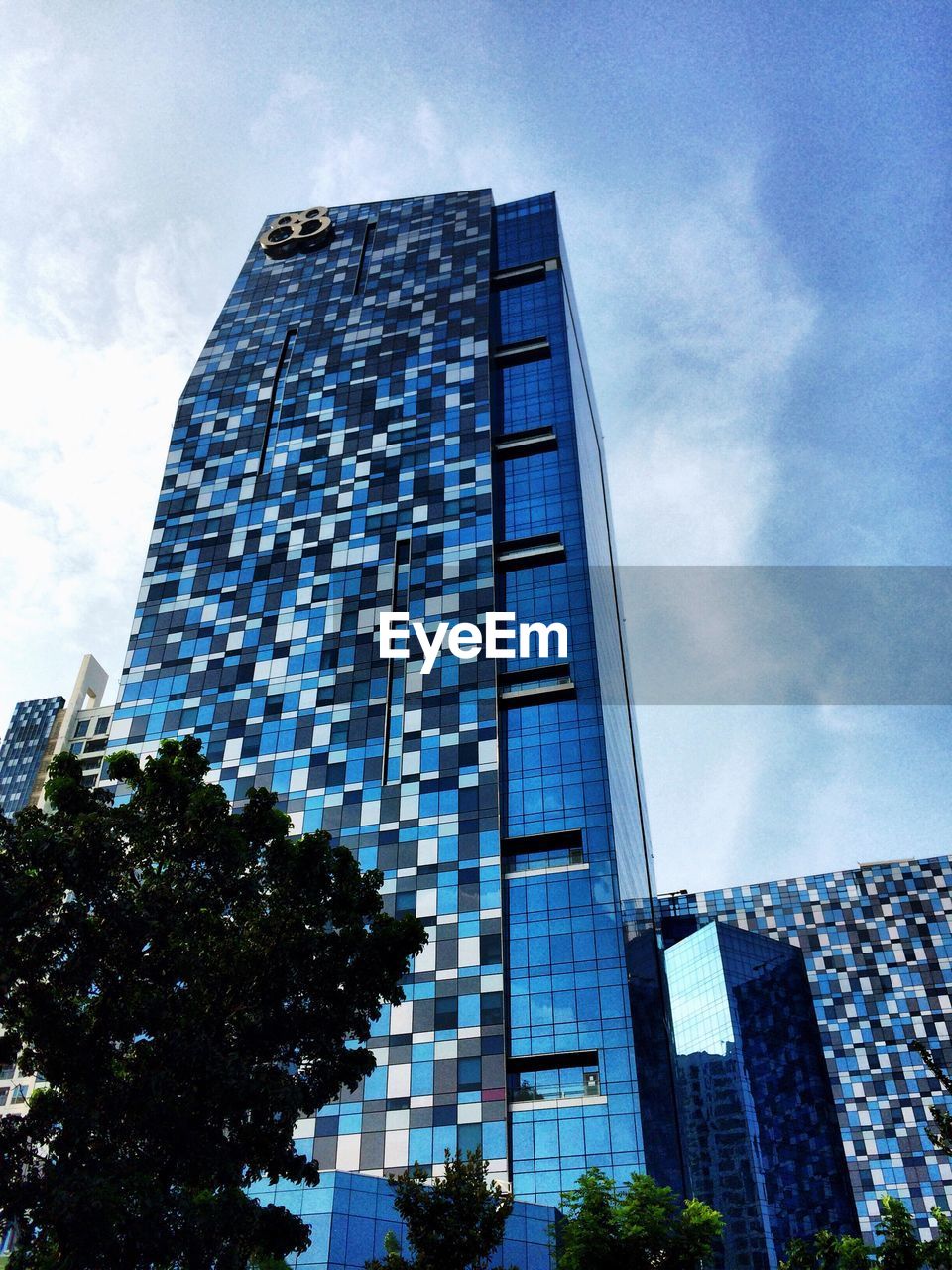 LOW ANGLE VIEW OF MODERN BUILDINGS AGAINST CLOUDY SKY