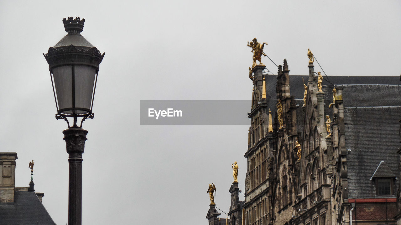 LOW ANGLE VIEW OF STREET LIGHT AGAINST BUILDING