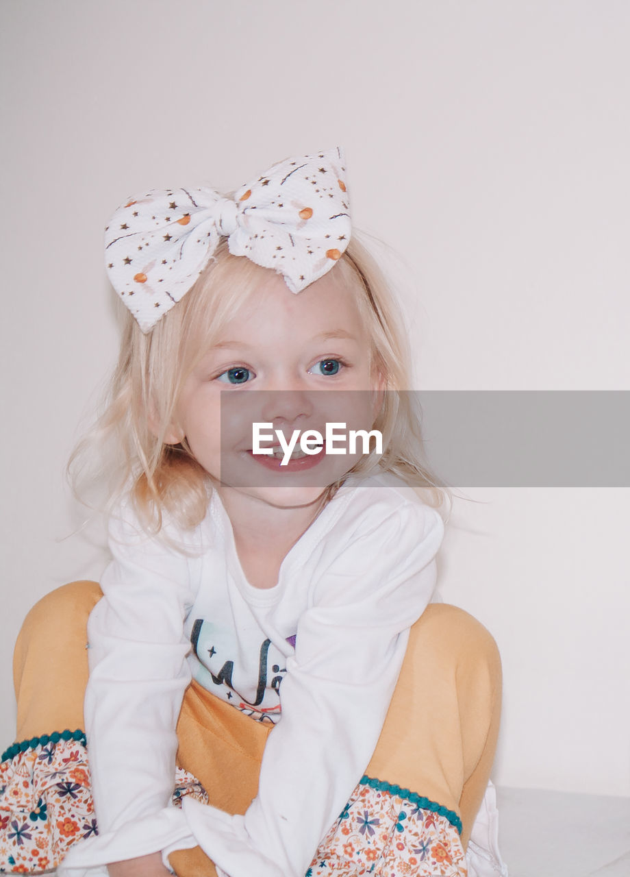 Smiling girl looking away while sitting at home