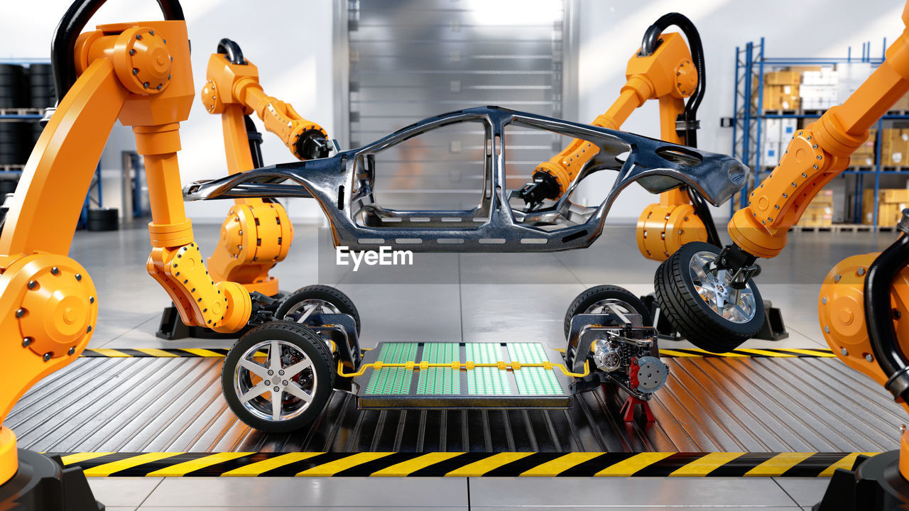 Assembly line in electric car factory with battery cells and industrial robotic arms, 3d rendering.