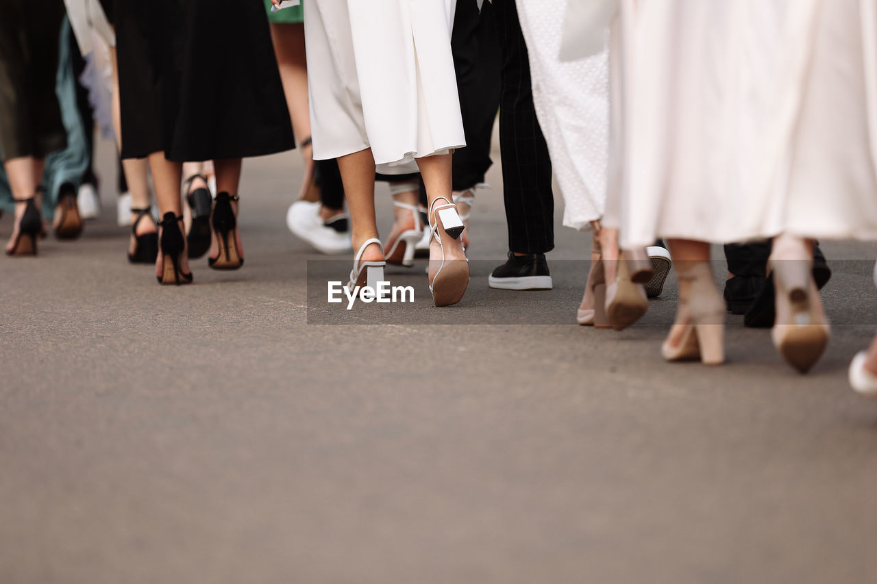 low section of people standing on road