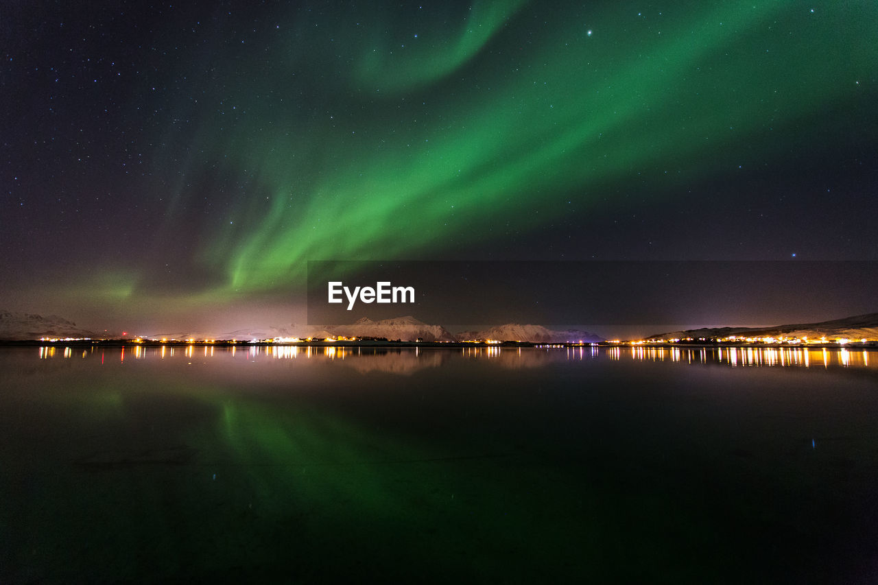 Scenic view of sea against aurora borealis at night