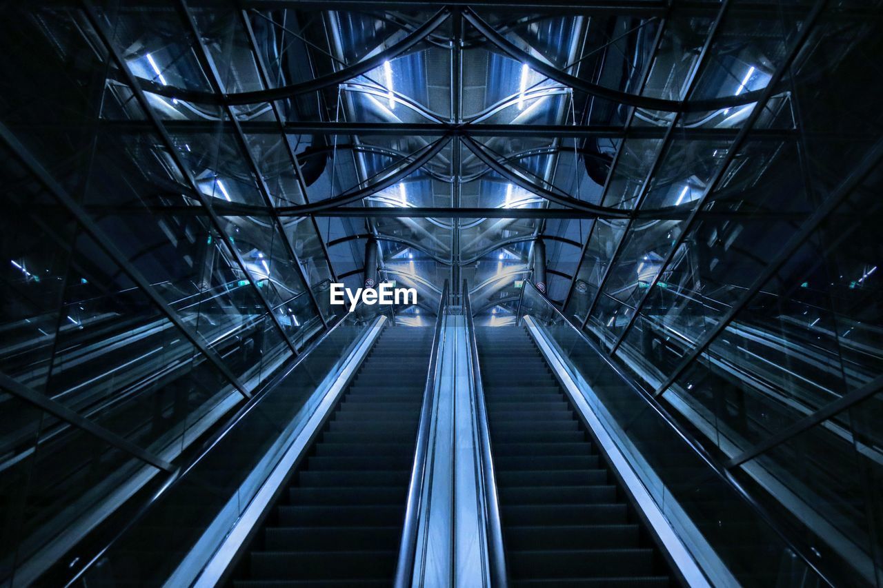 LOW ANGLE VIEW OF ESCALATOR IN ILLUMINATED CEILING