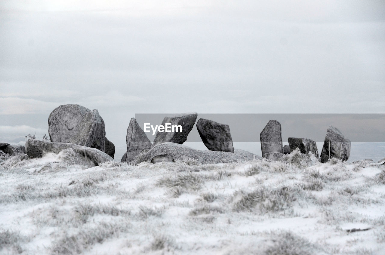 The standing stones of a neolithic portal tomb on a hilltop in winter