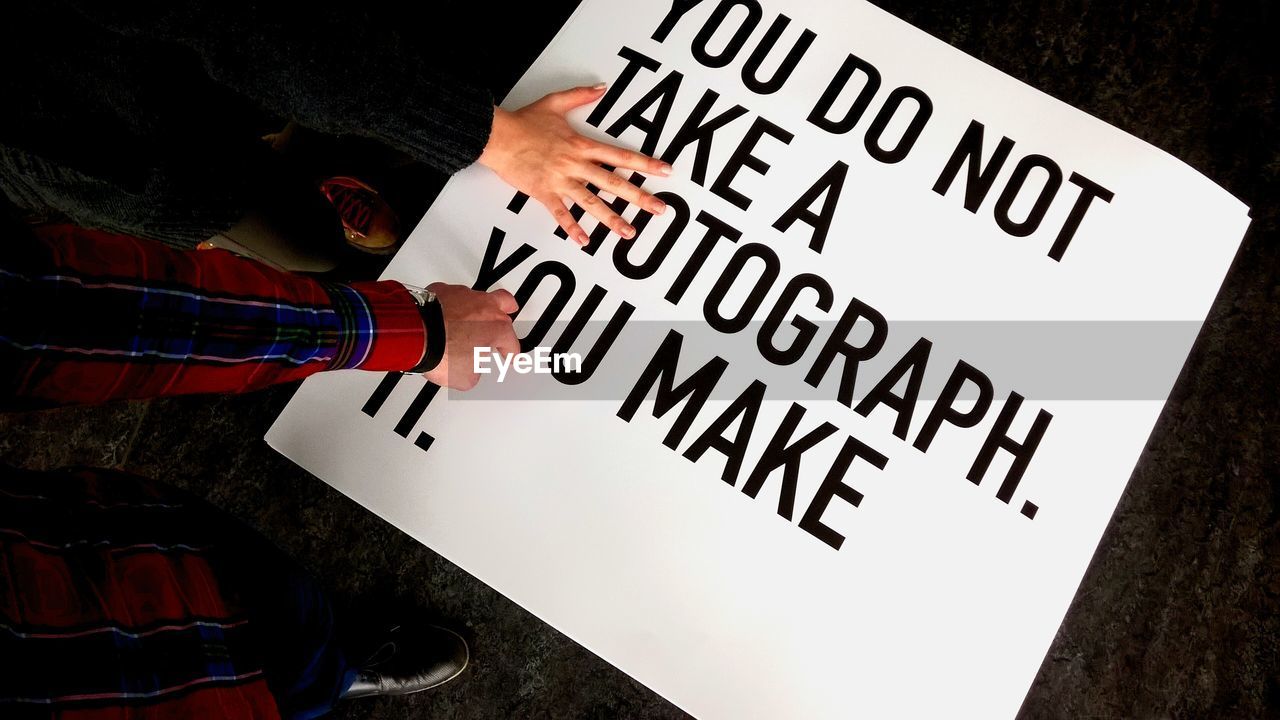 High angle view of hands on sign