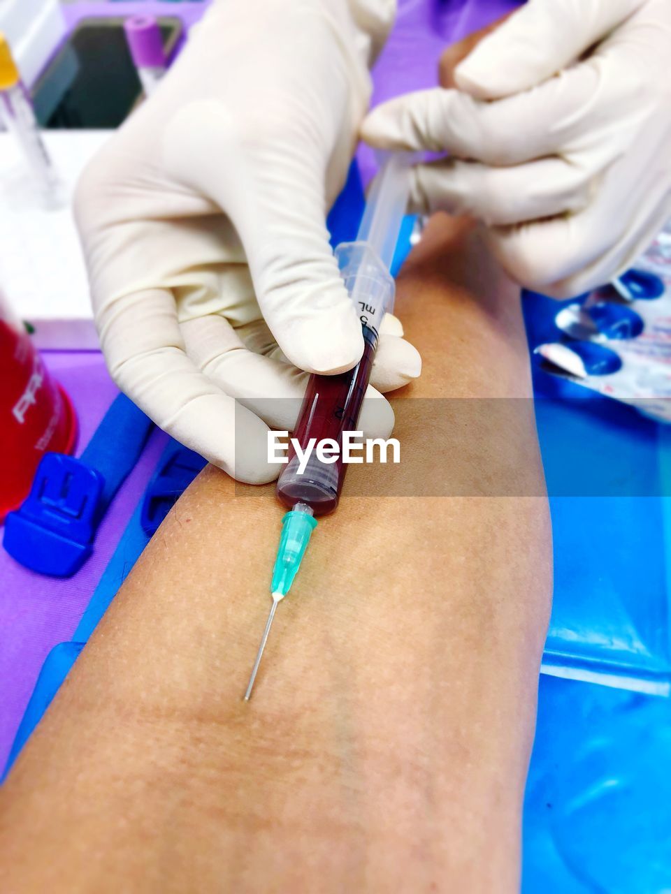 Cropped hands injecting woman in hospital