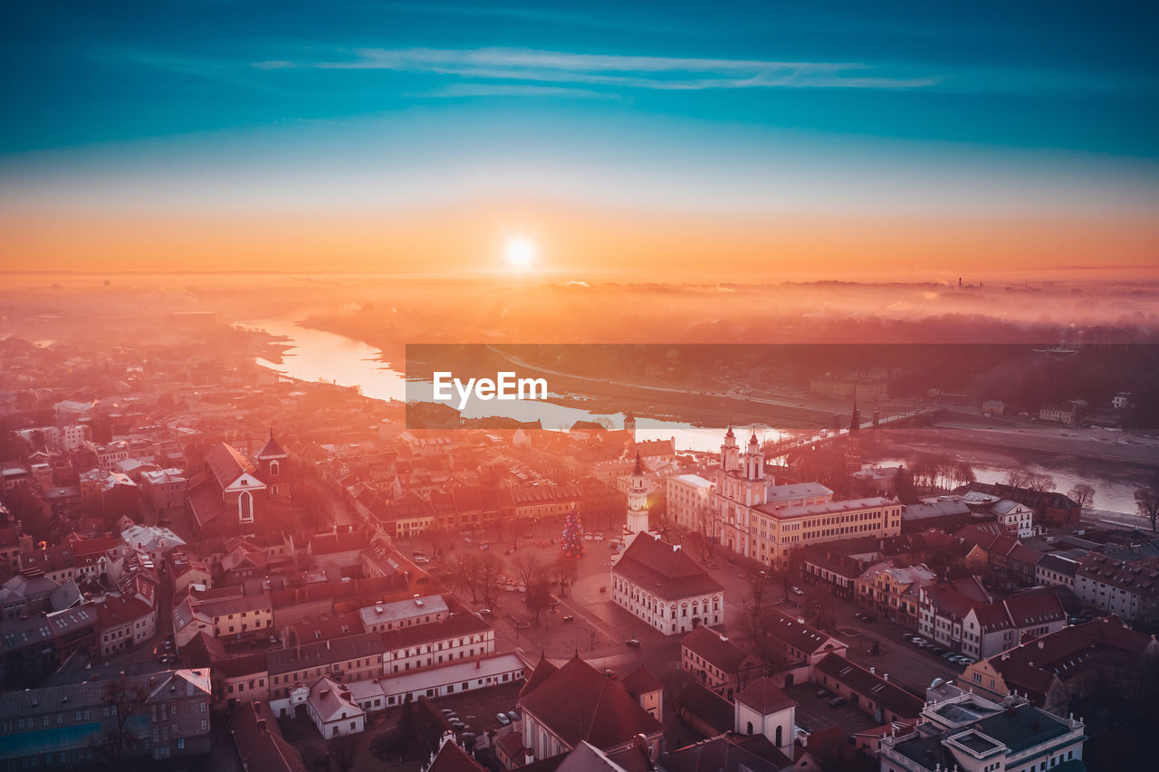 Aerial view of townscape against sky at sunset