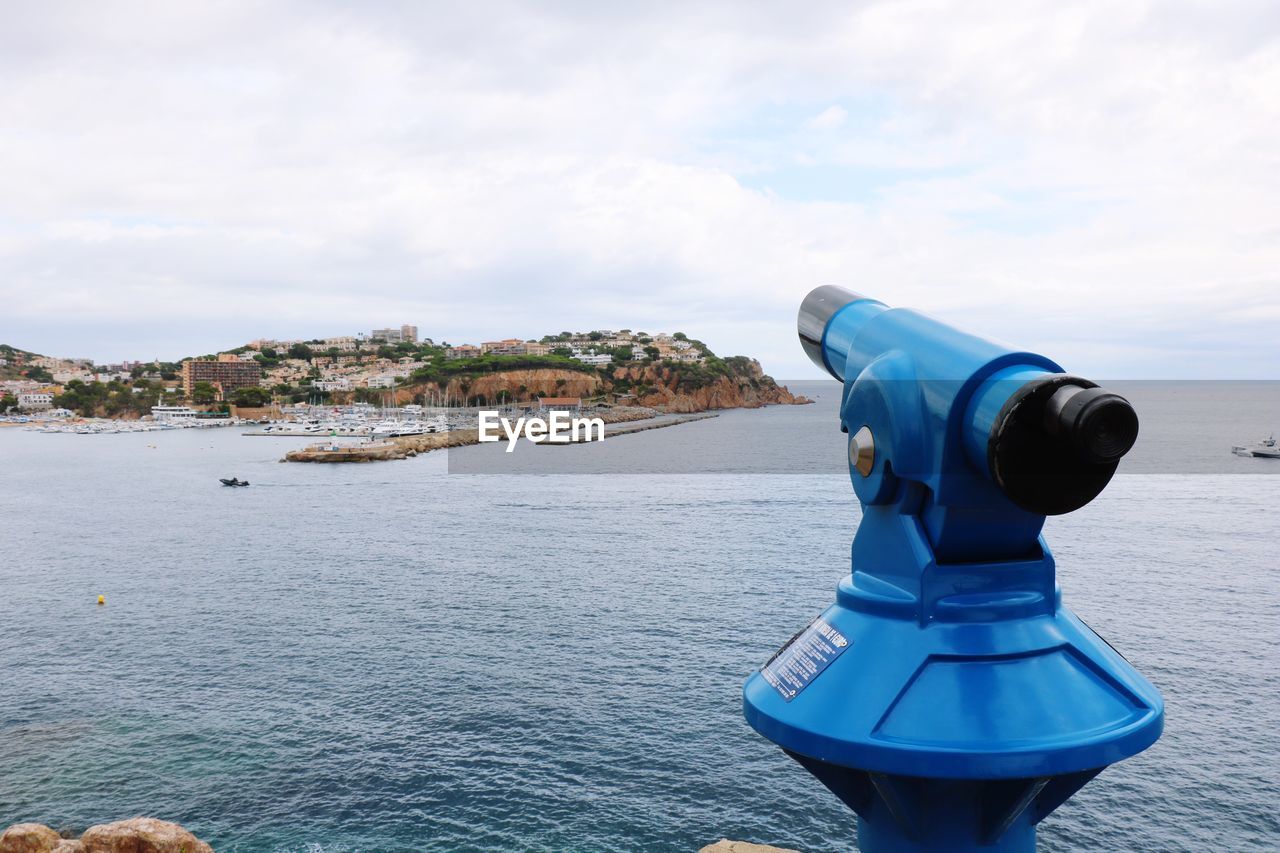 CLOSE-UP OF COIN-OPERATED BINOCULARS AGAINST SKY