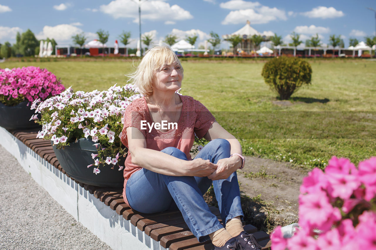 Woman sitting by flowering plants