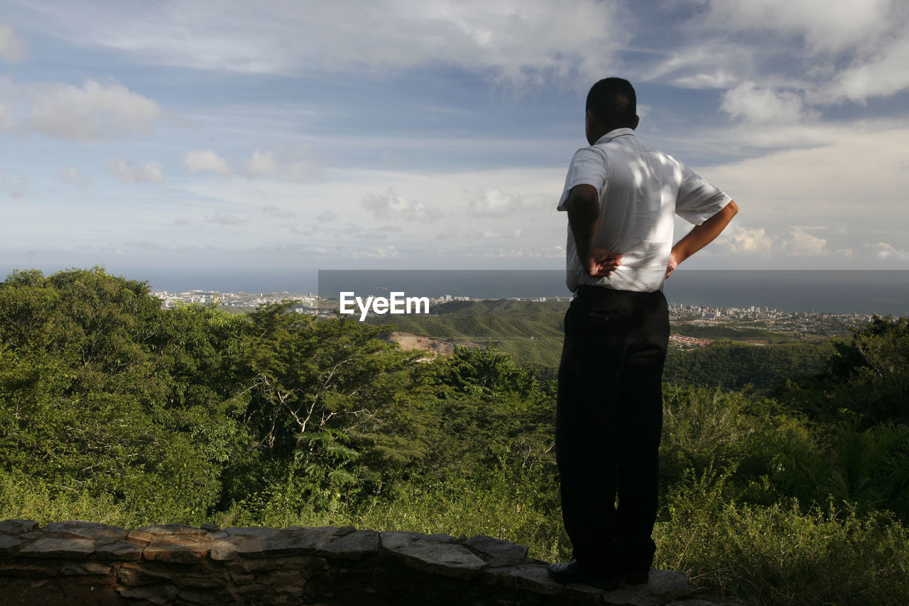 Man standing on rock looking at valley