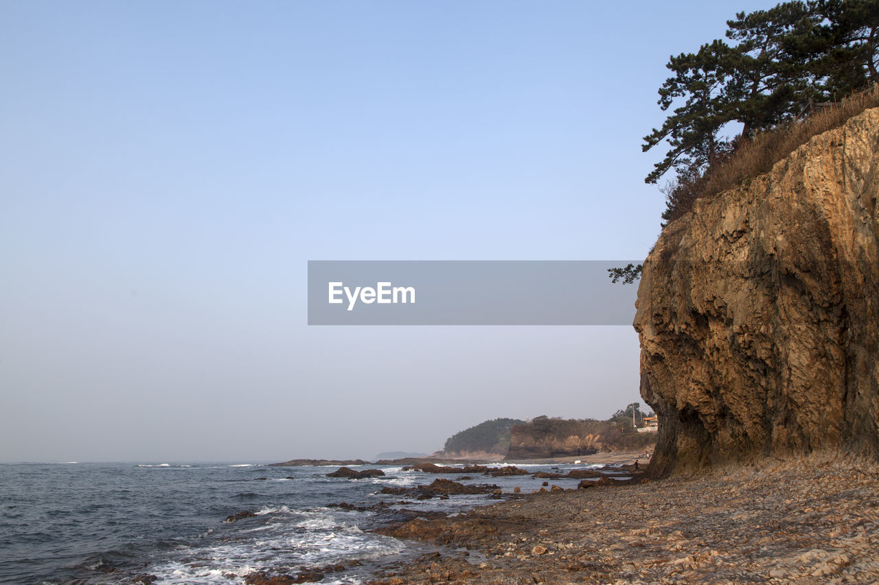 Scenic view cliff at gyeokpo beach against clear sky