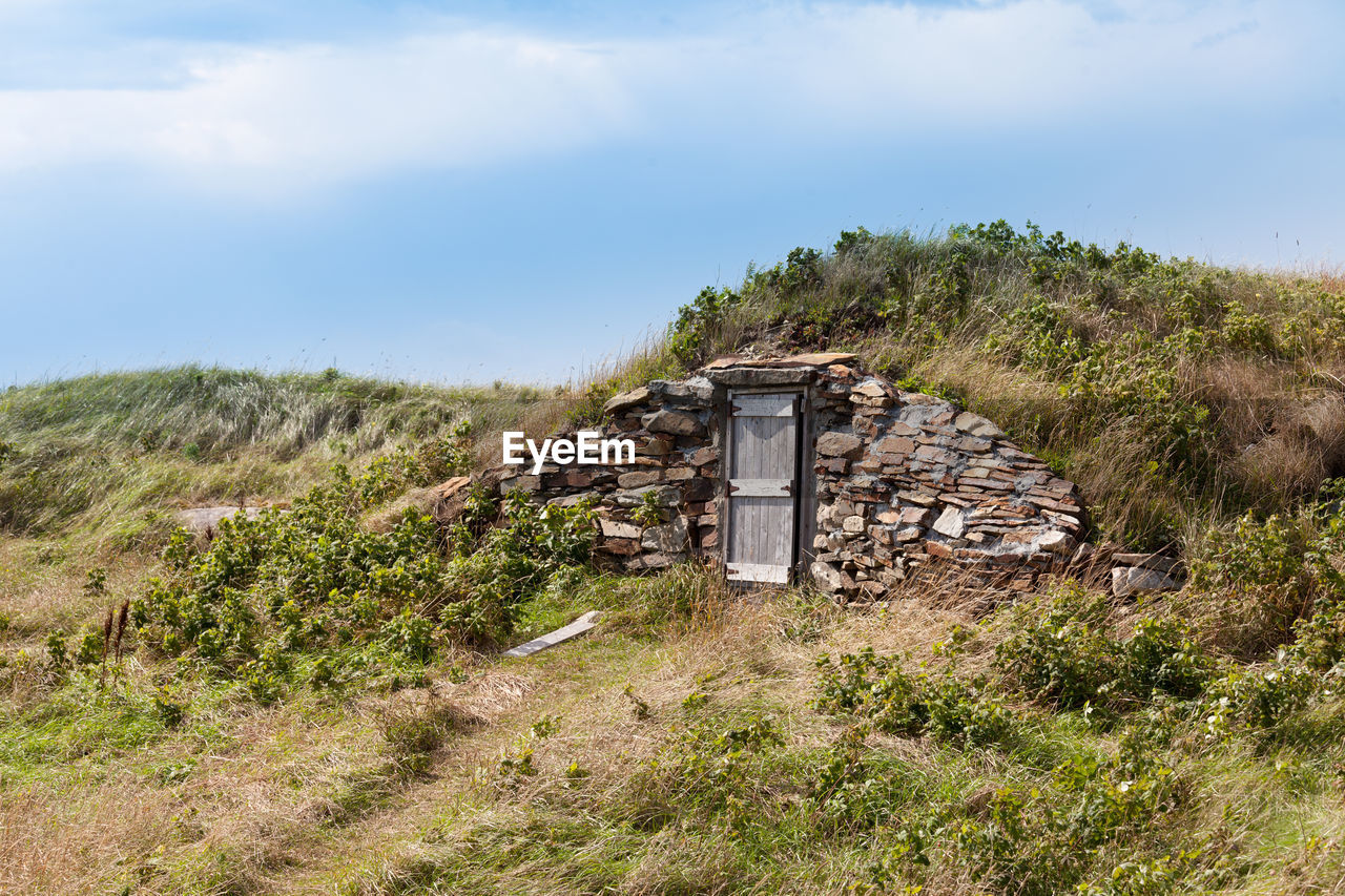 ABANDONED BUILDING ON FIELD