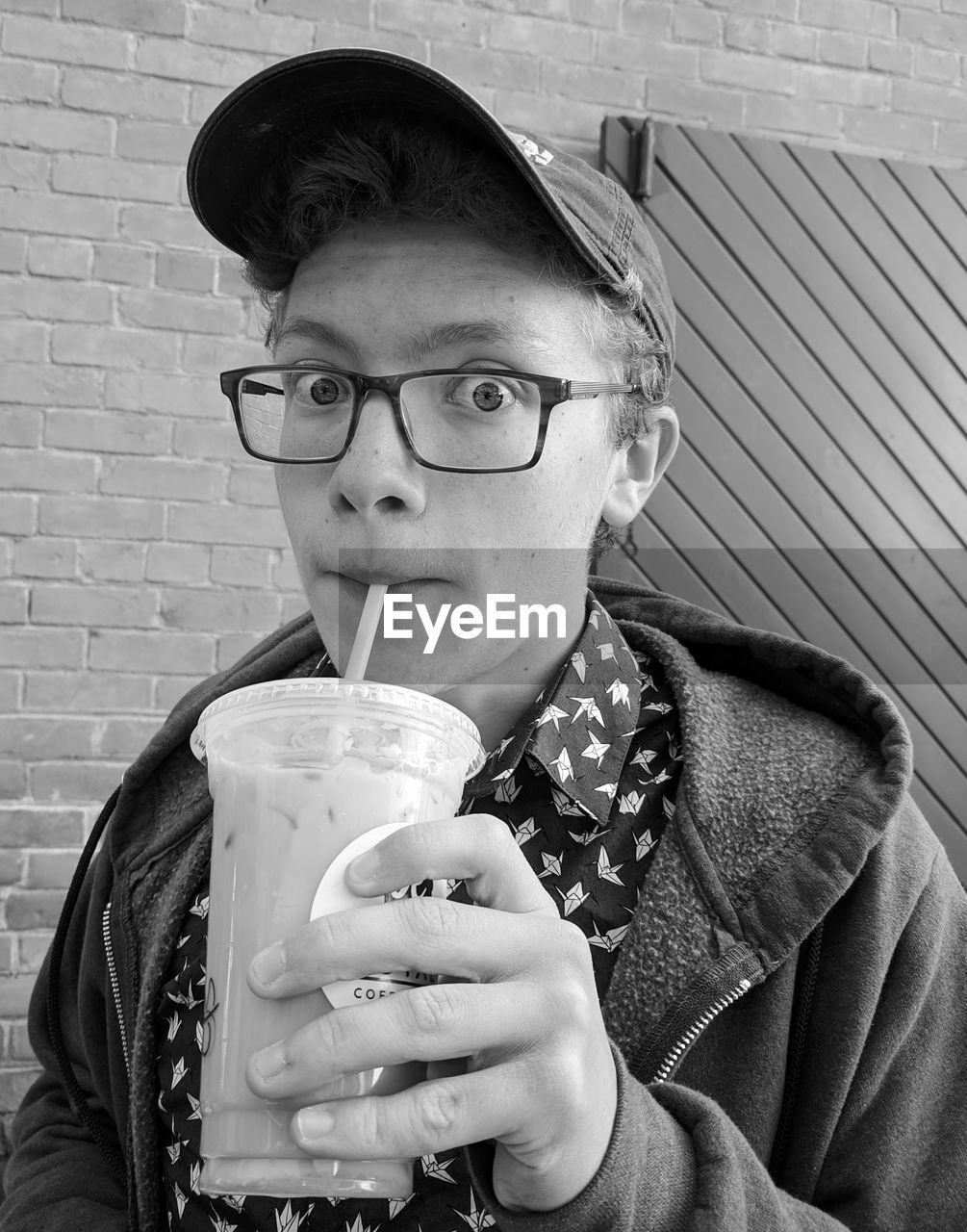 Black and white portrait of teenage boy drinking coffee and relaxing