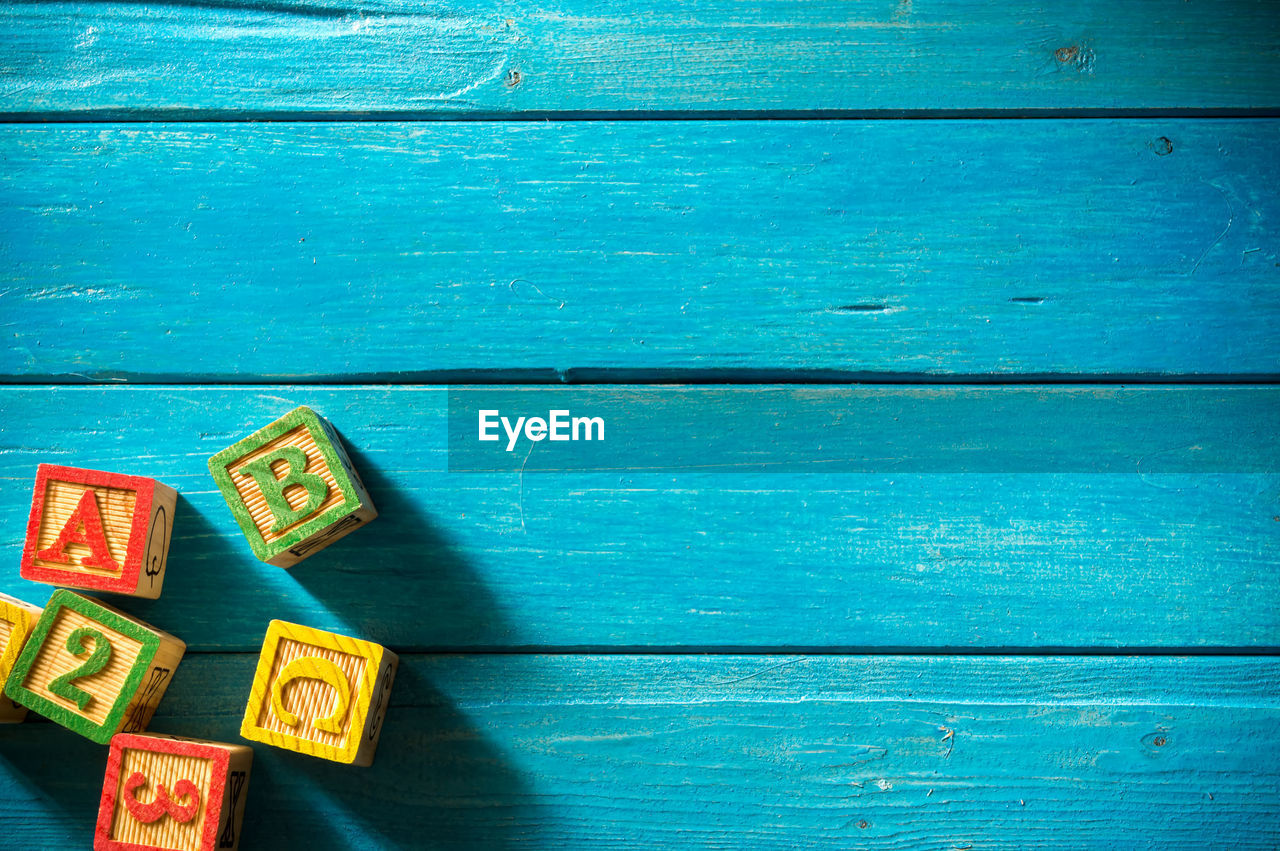 High angle view of colorful toy blocks on blue wooden table