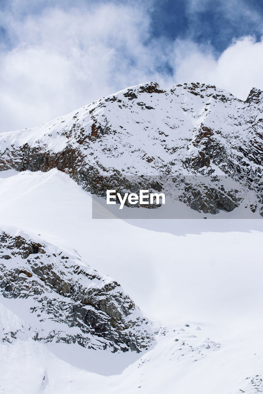 snow, cold temperature, winter, mountain, environment, landscape, scenics - nature, sky, beauty in nature, mountain range, cloud, nature, snowcapped mountain, travel destinations, travel, no people, ridge, coniferous tree, tourism, piste, tranquility, outdoors, day, pinaceae, forest, polar climate, frozen, land, tranquil scene, pine woodland, pine tree, non-urban scene, mountain peak, ski touring, ski mountaineering, holiday, overcast, tree