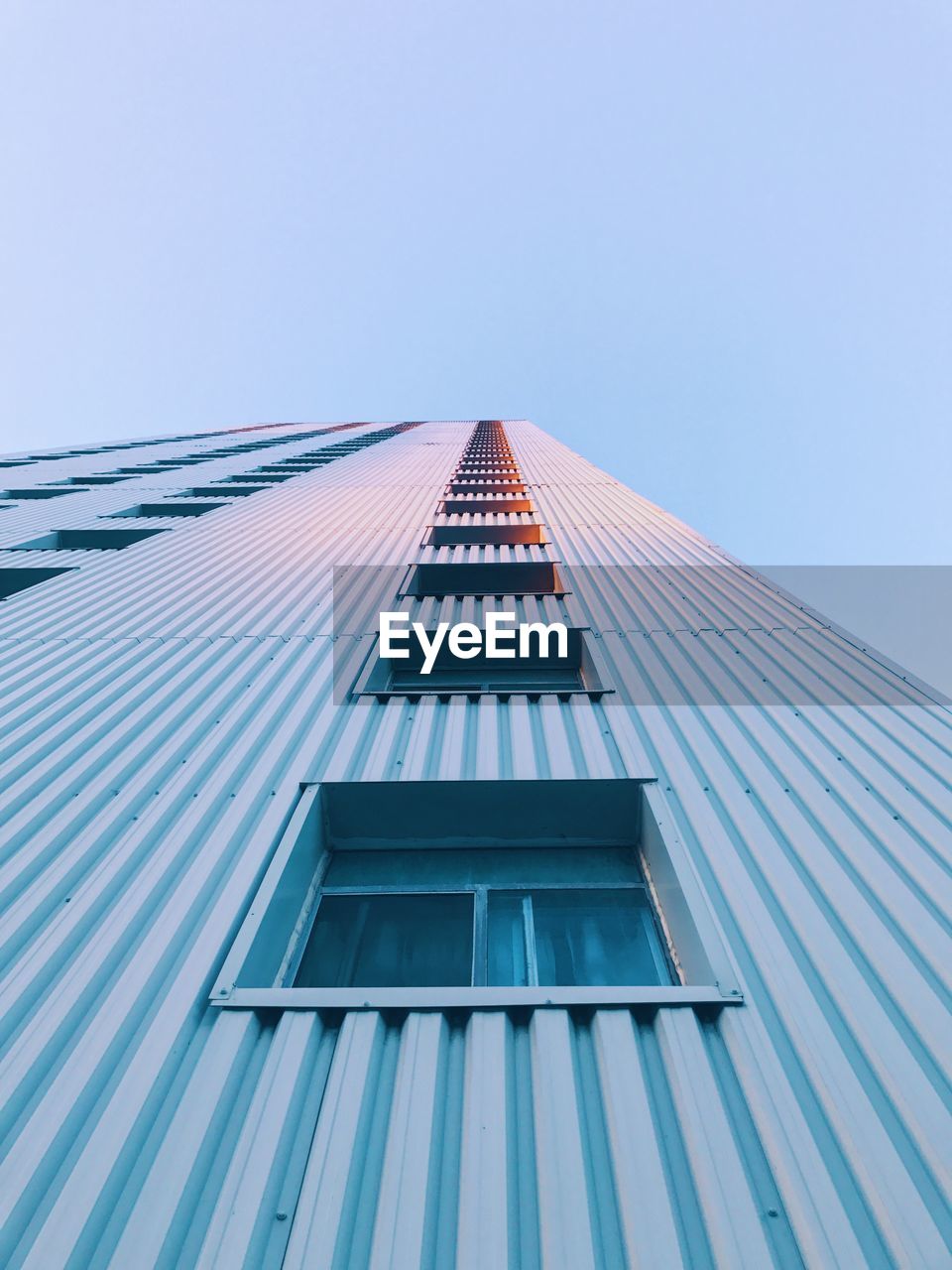 LOW ANGLE VIEW OF MODERN OFFICE BUILDING AGAINST CLEAR SKY