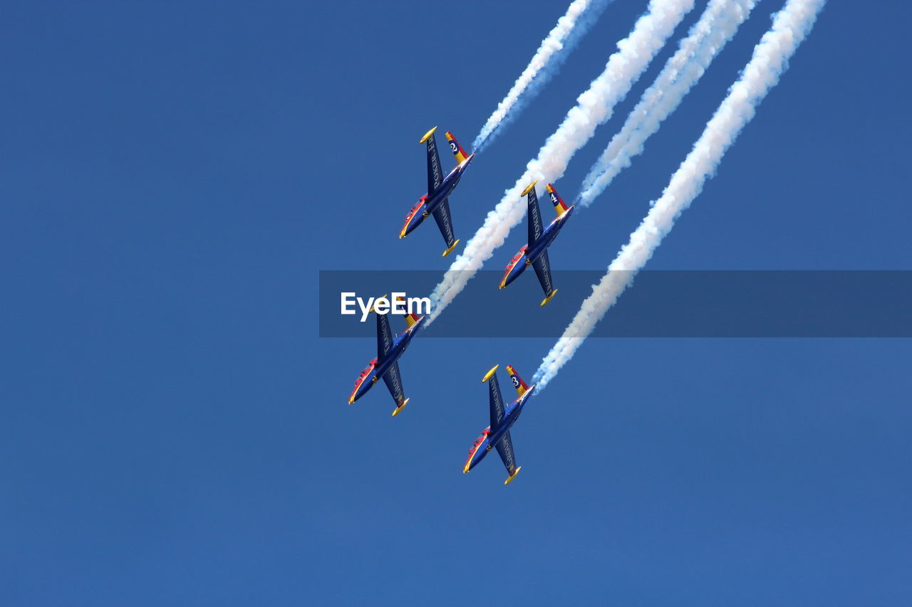 LOW ANGLE VIEW OF AIRSHOW AGAINST SKY