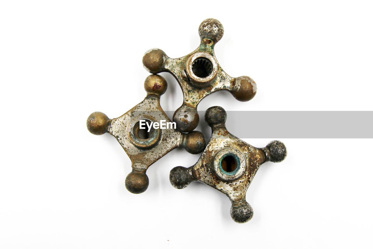 Close-up of old rusty knobs against white background