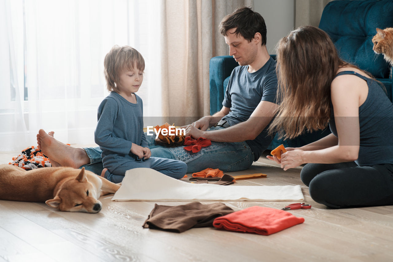 Family leisure activity. happy family making diy snuffle mats for their domestic dog and cat