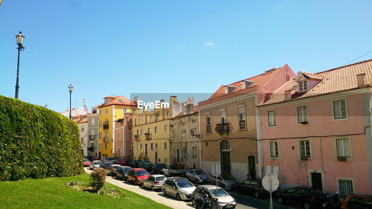 BUILDINGS BY STREET AGAINST BLUE SKY