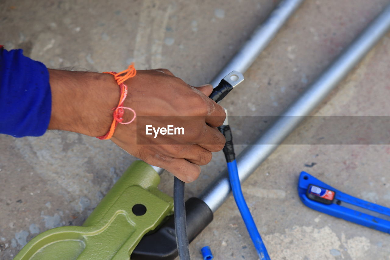 HIGH ANGLE VIEW OF MAN WORKING ON METAL FLOOR