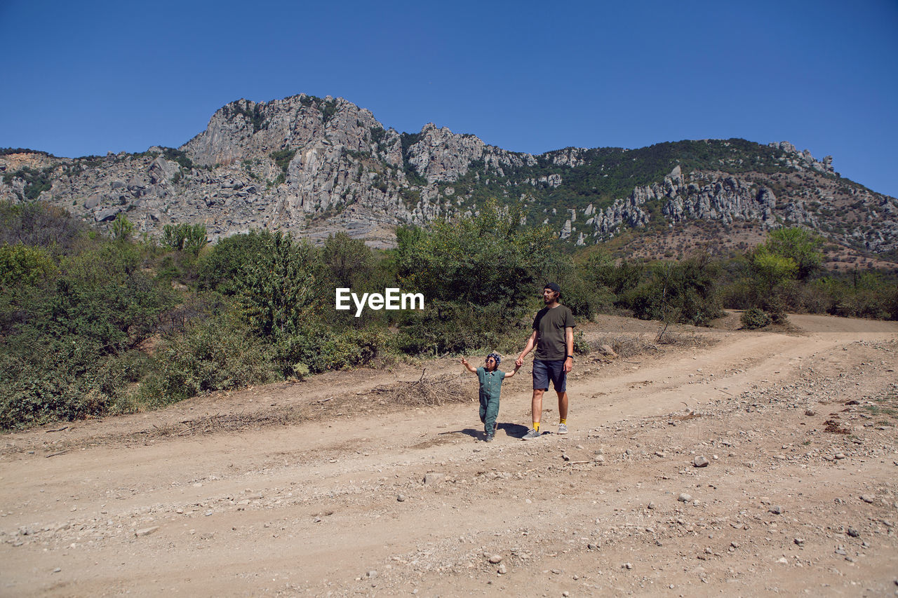 Boy child travels with his father through the mountains in the summer in the crimea