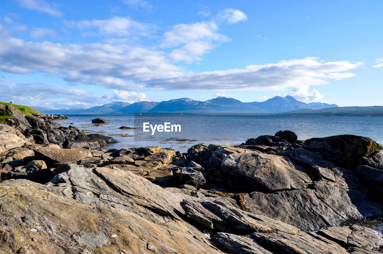 Scenic view of sea and mountains against sky