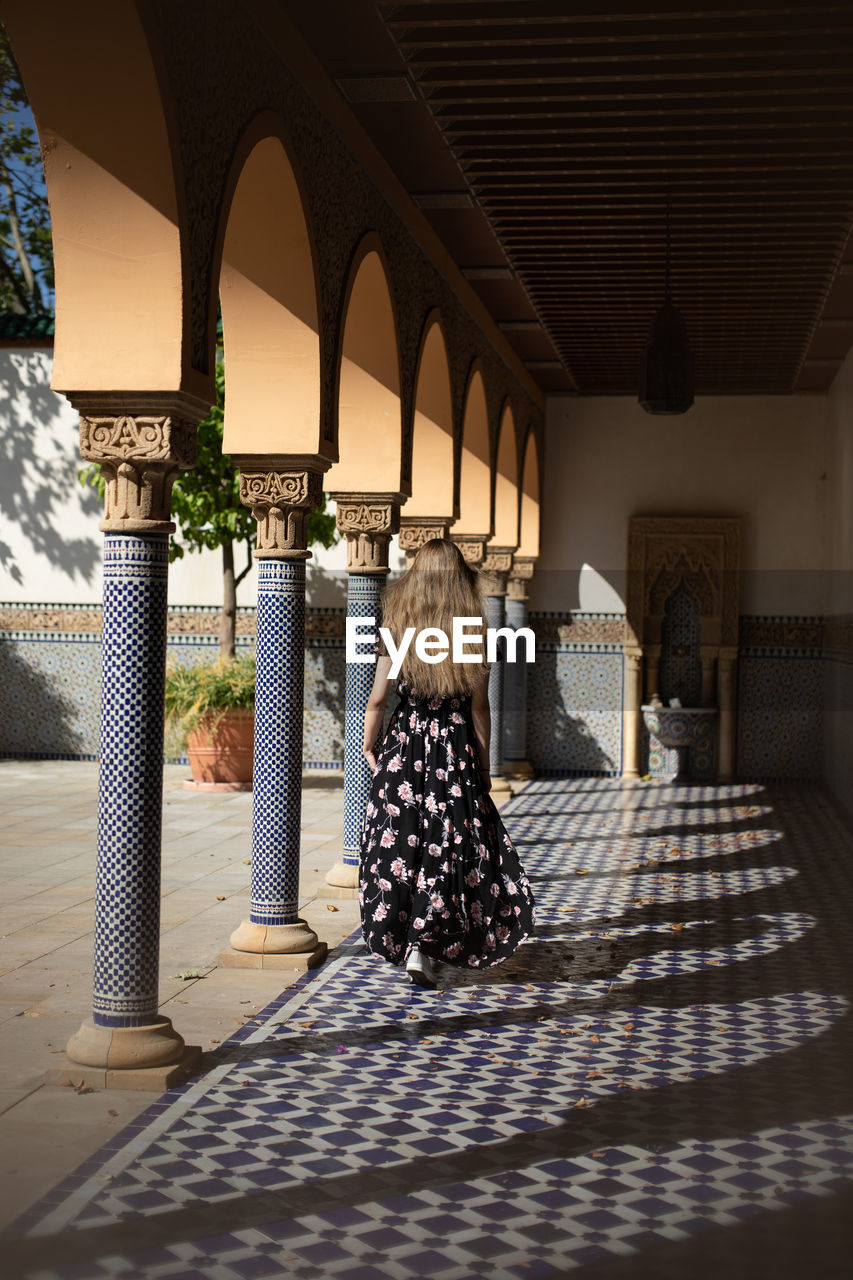 Full length of woman walking in illuminated corridor