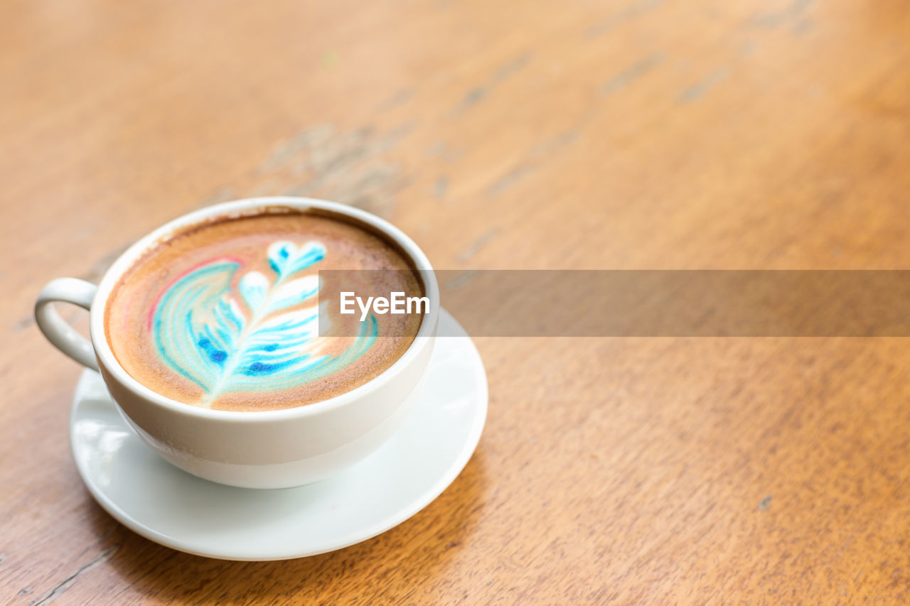 High angle view of colorful coffee on wooden table