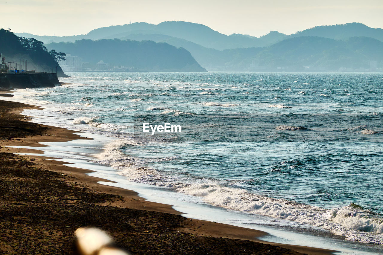 SCENIC VIEW OF SEA AGAINST MOUNTAIN