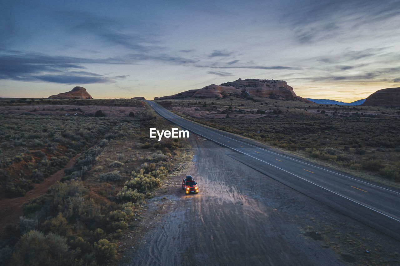 Lonely utah's road in the evening with a pulled over car