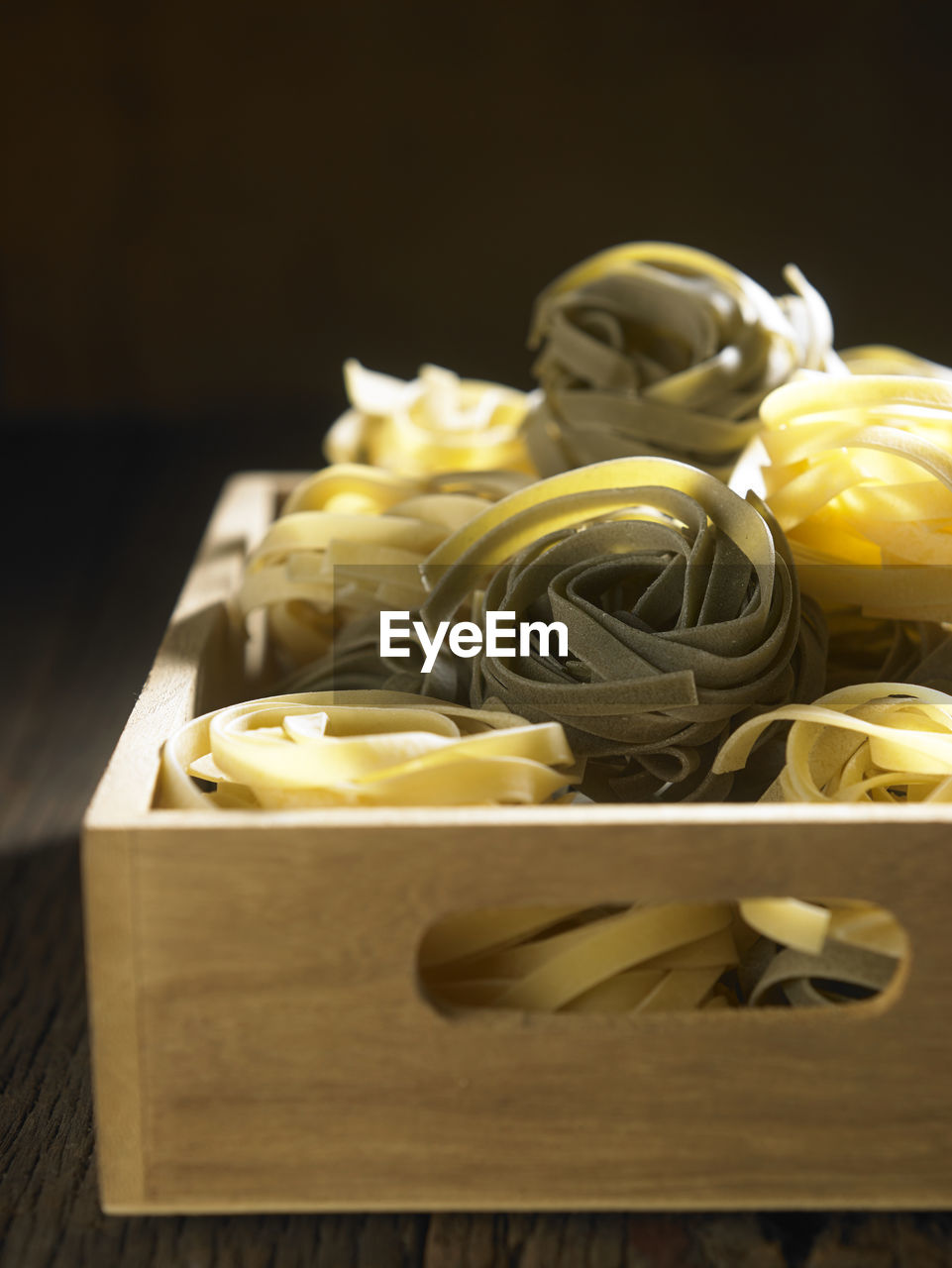 Directly above shot of tagliatelle pasta in crate on table