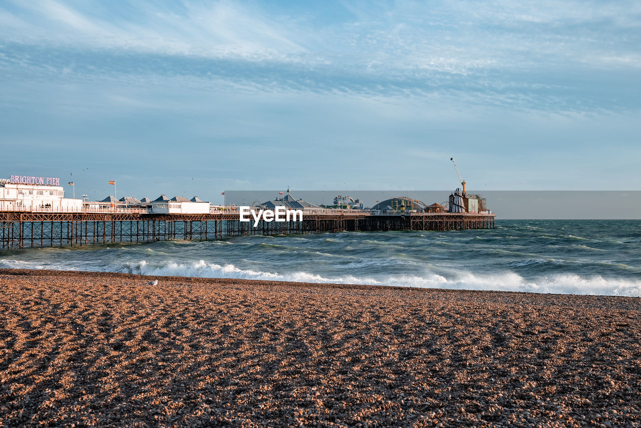 People walking down the promenade near the beach in brighton.