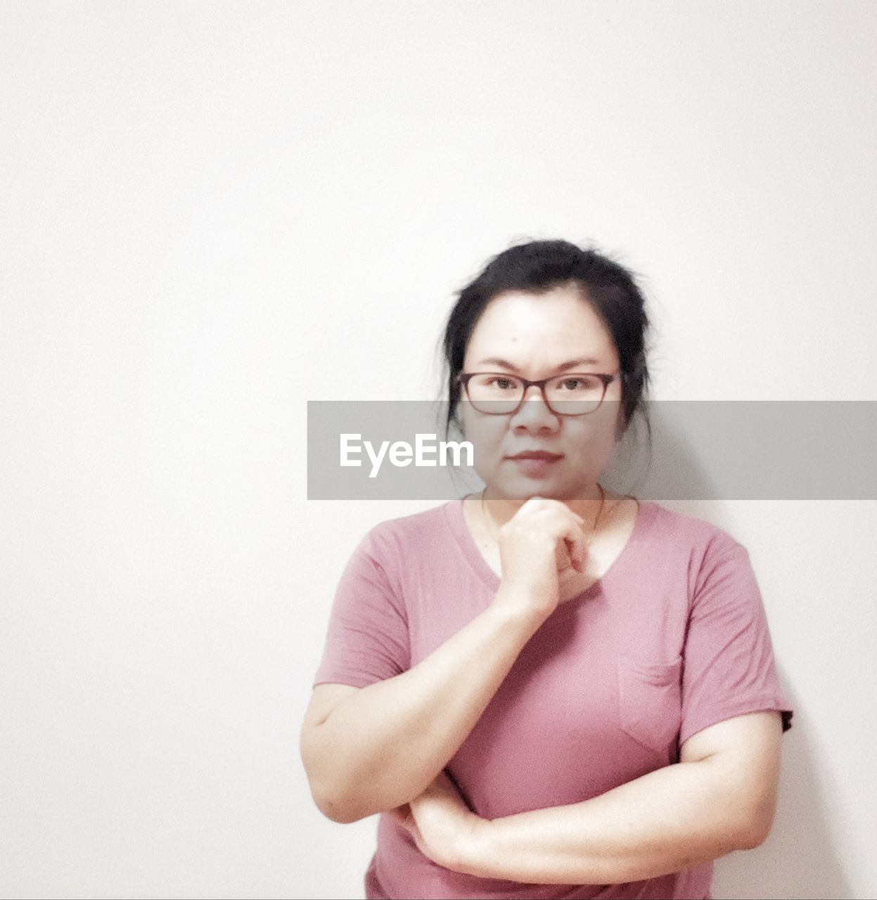 PORTRAIT OF WOMAN STANDING AGAINST WHITE BACKGROUND