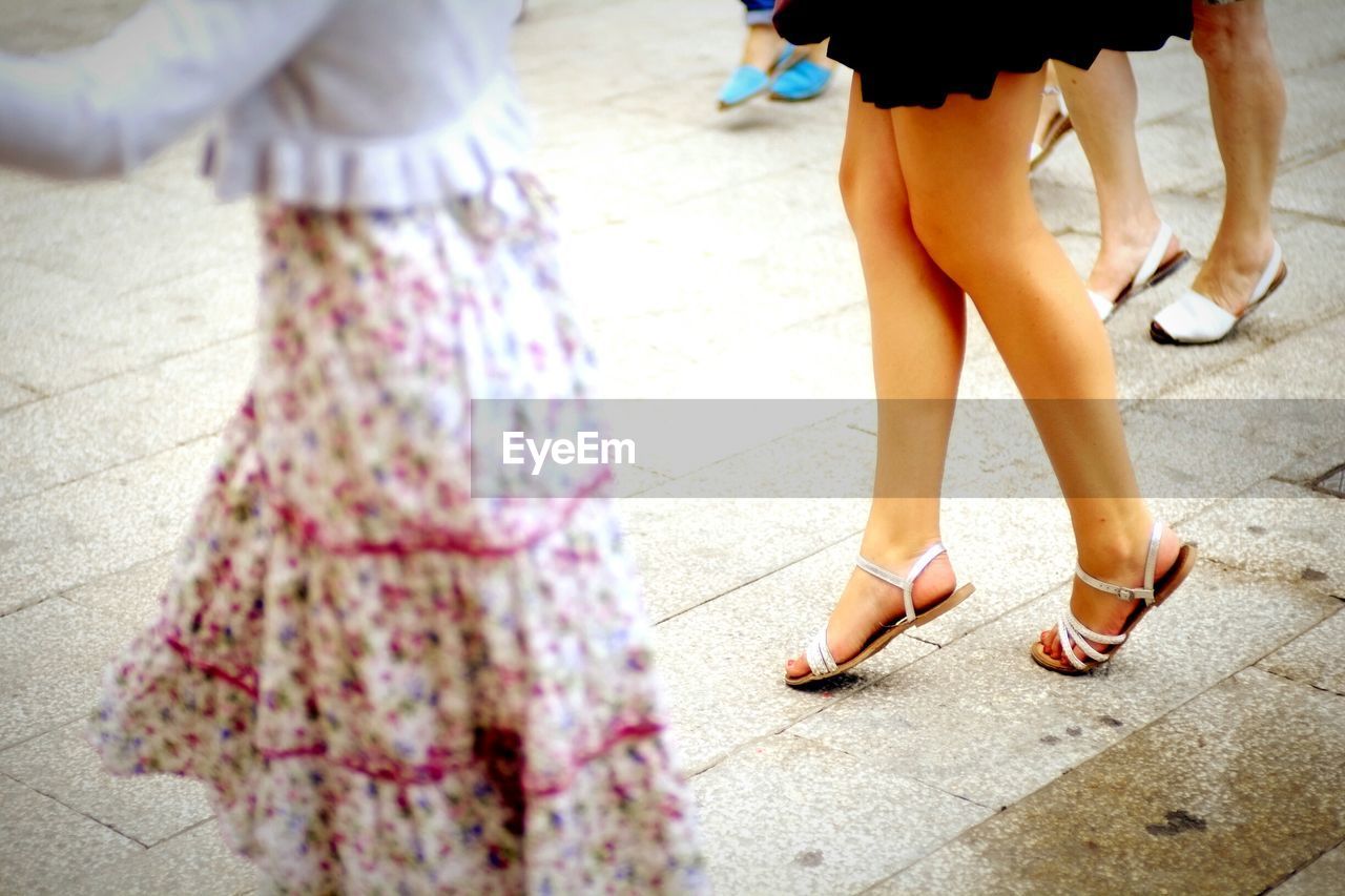 Low section of women standing on street