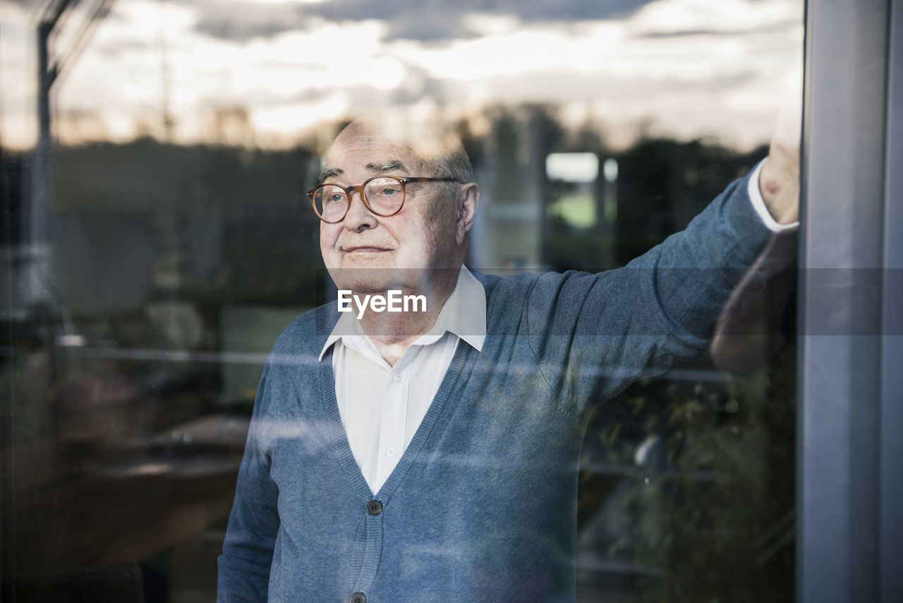 Portrait of serious man at the window looking out