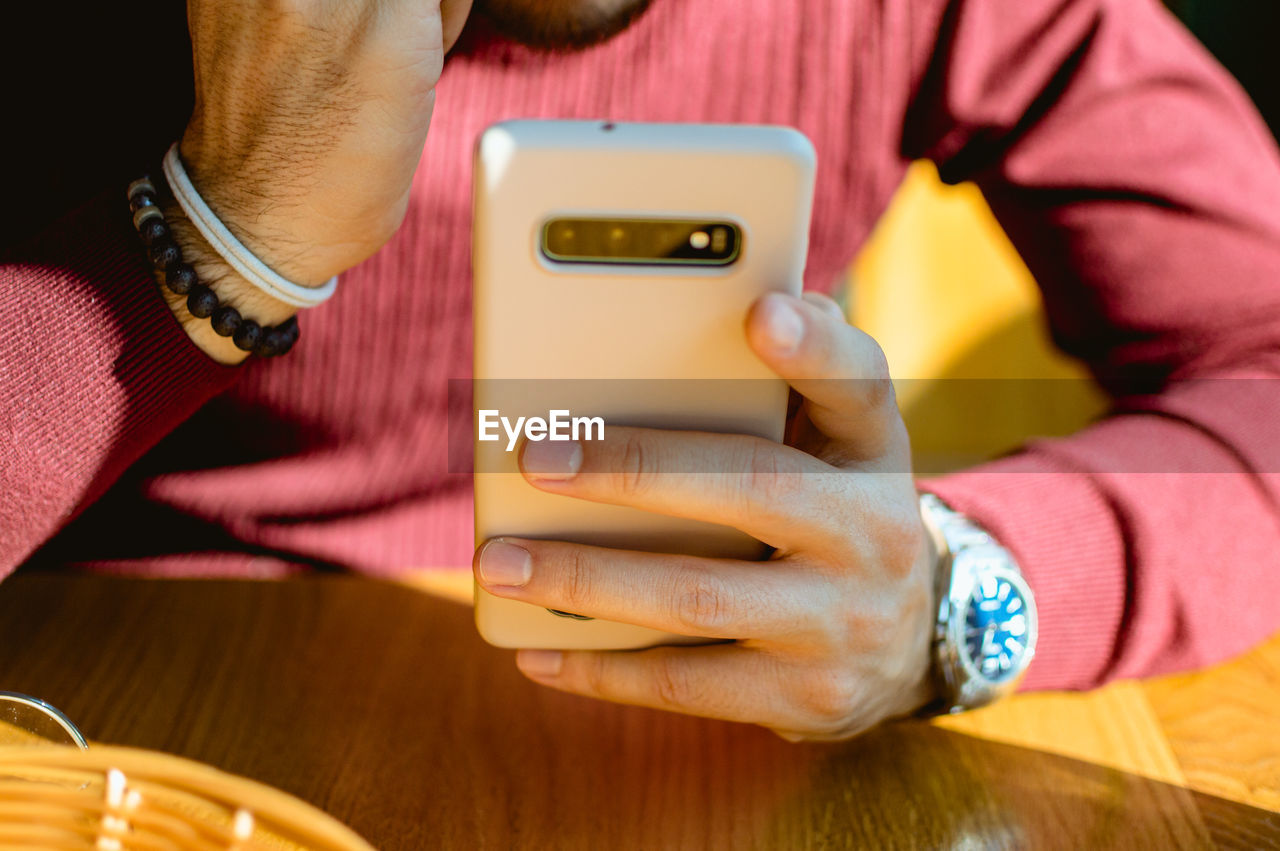 Man holding a phone at a restaurant table in vienna, austria