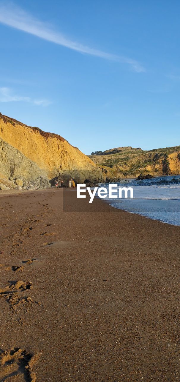 Scenic view of beach against blue sky