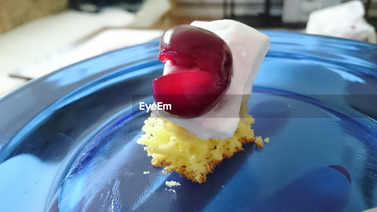 Close-up of cake slice with cherry in plate