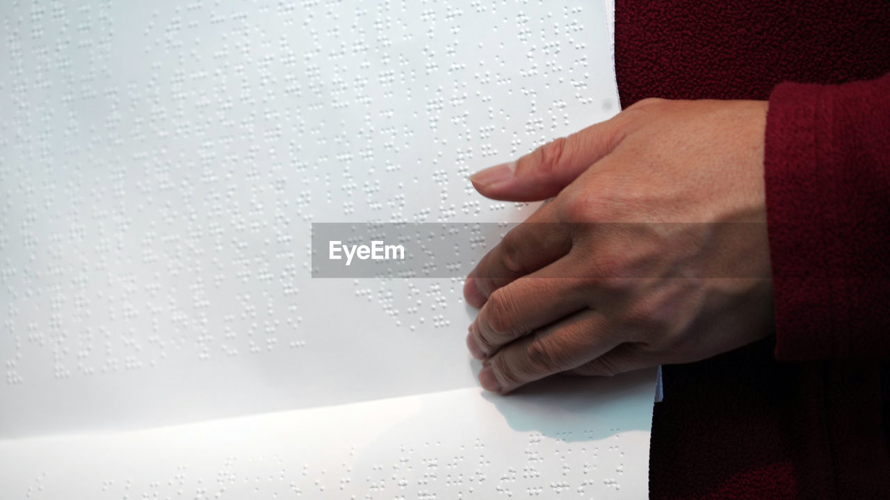 Cropped image of woman touching braille
