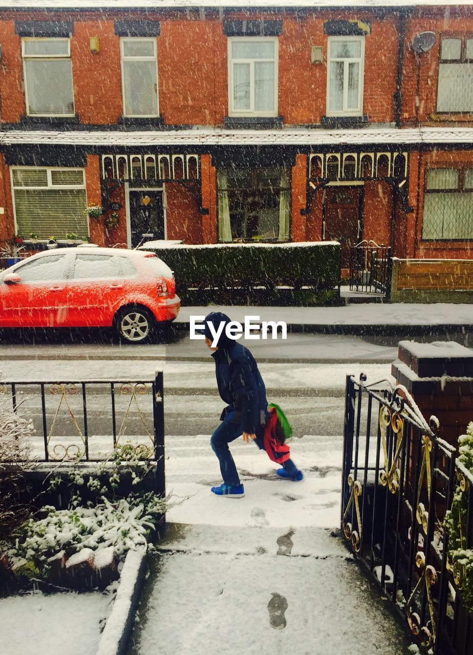 Boy walking on sidewalk