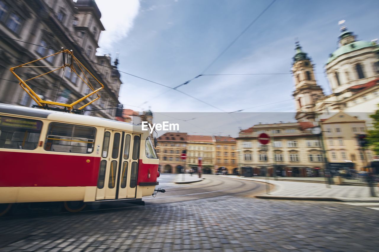 Train on street amidst buildings in city