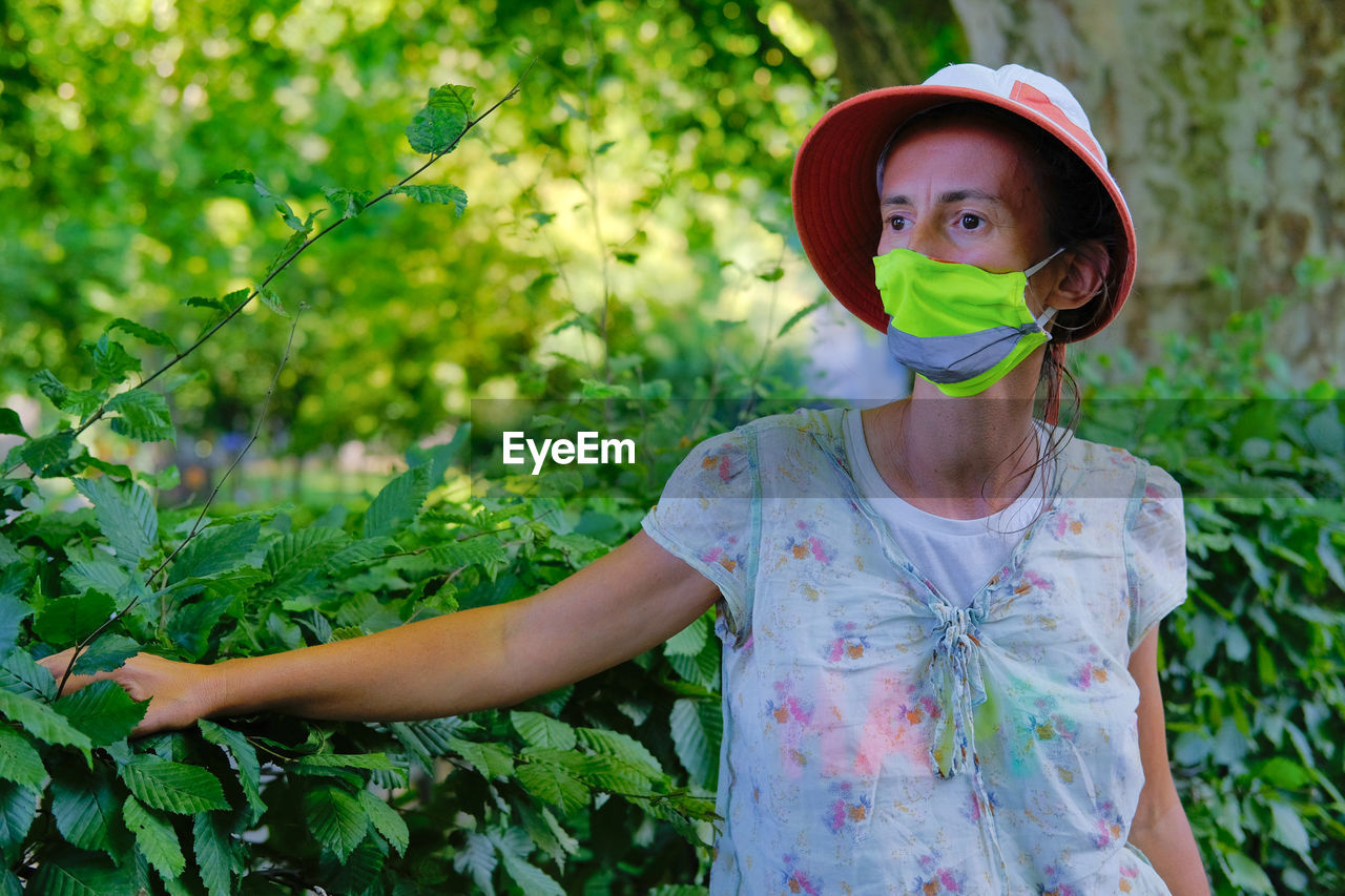 Portrait of woman standing by plants